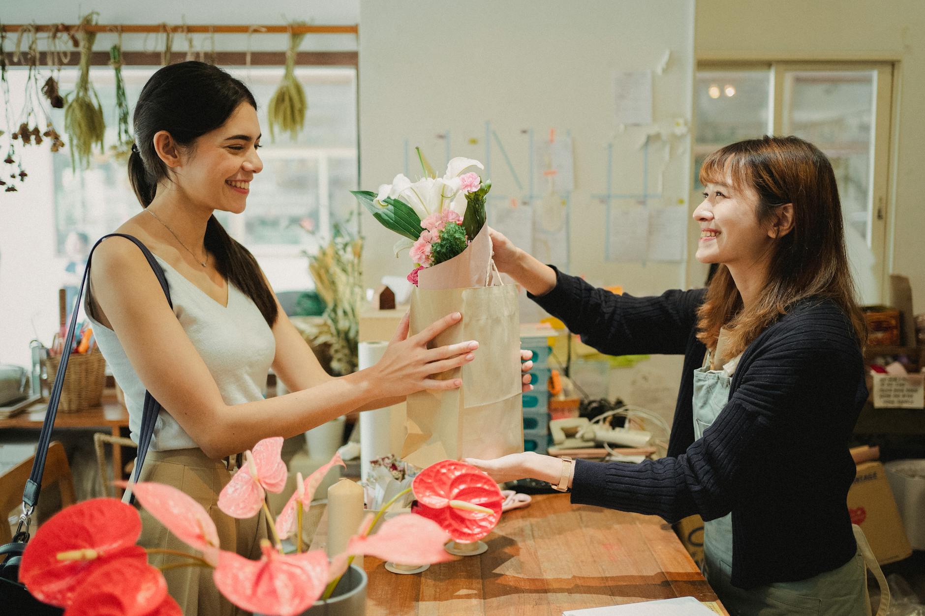 happy florist giving bouquet of flowers to lady